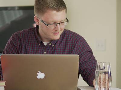 Online student using a laptop in a business setting.